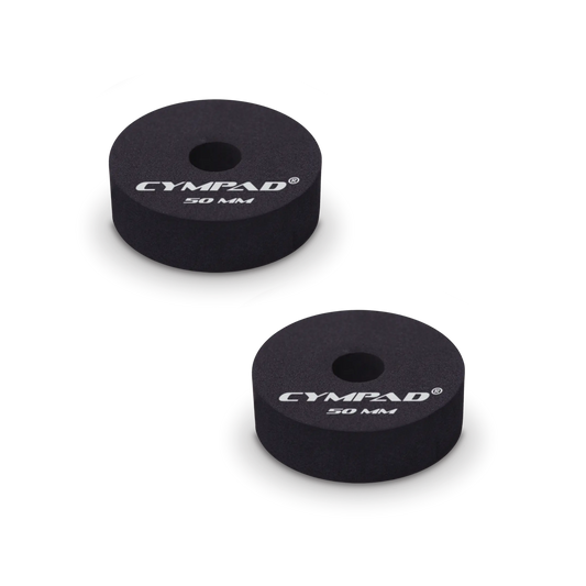 Two black Cympad Moderator cymbal washers, each 50mm in diameter, with a central hole and white printed branding that reads 'CYMPAD 50 MM.' The pads are round, made of cellular foam, and designed to reduce cymbal sustain and volume.