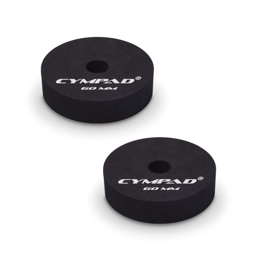 Two black Cympad Moderator cymbal washers, each 60mm in diameter, with a central hole and white printed branding that reads 'CYMPAD 60 MM.' The pads are round, made of cellular foam, and designed to reduce cymbal sustain and volume.