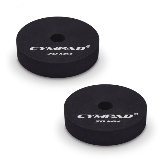 Two black Cympad Moderator cymbal washers, each 70mm in diameter, with a central hole and white printed branding that reads 'CYMPAD 70 MM.' The pads are round, made of cellular foam, and designed to reduce cymbal sustain and volume.