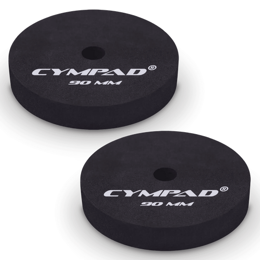 Two black Cympad Moderator cymbal washers, each 90mm in diameter, with a central hole and white printed branding that reads 'CYMPAD 90 MM.' The pads are round, made of cellular foam, and designed to reduce cymbal sustain and volume.