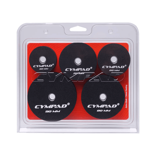 Front view of Cympad Moderator Super Set in retail packaging – Includes five pairs of cymbal washers in assorted sizes (50mm to 90mm), designed to control cymbal volume and overtones. Features black foam pads with white Cympad logos, set against a orange background inside clear clamshell packaging.
